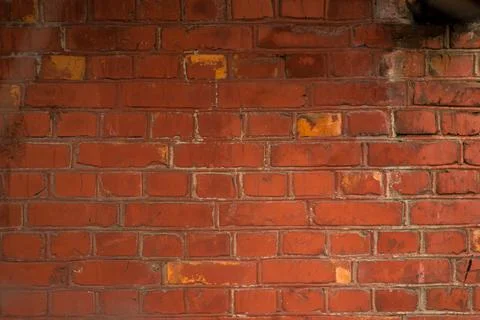 Rough red brick wall with traces of old age and with different shades of bric Stock Photos