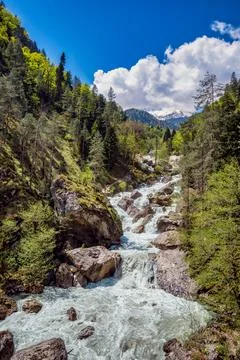 The rough river flows from mighty rocks of Ghagra ridge in Abkhazia. Stock Photos