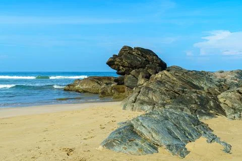 Rough rock formation on the beach on the shore Stock Photos