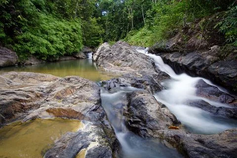 Rough rocks and fast-streaming creek in wild forest Stock Photos