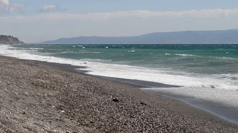 The rough sea hits the beach with wind and mist while a seagull takes flight Stock Footage 84027334