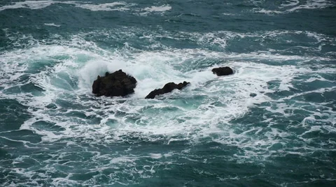 Rough sea washes over shallow rocks, slow motion Stock Footage 56114546