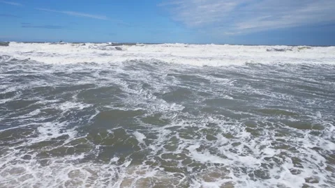 Rough sea waves crashing under bright blue sky with scattered clouds over o.. Stock Footage 339574321