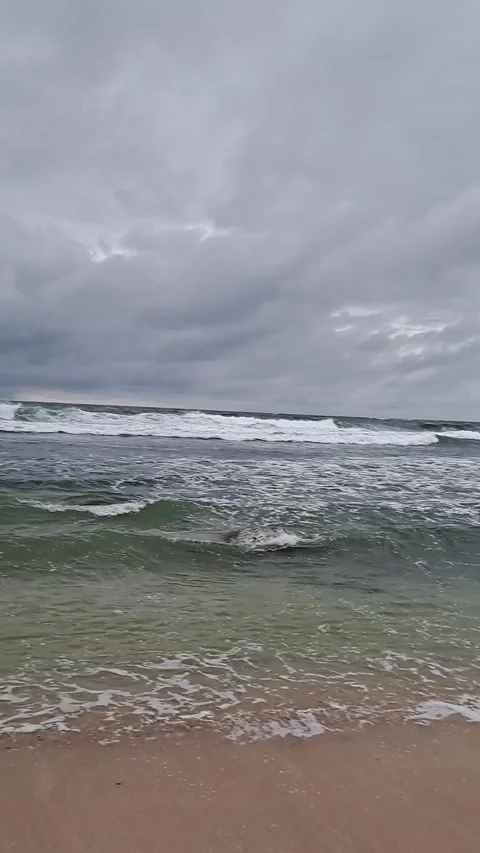 Rough Sea Waves on Sandy Beach Under Cloudy Sky 動画素材 331416048