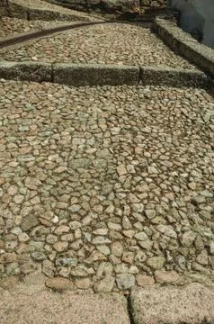 Rough stone pavement in pathway made of large stairs Stock Photos