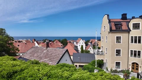 From rough stone wall across Visby rooftops toward beige historic — Visby Vidéo 347671130