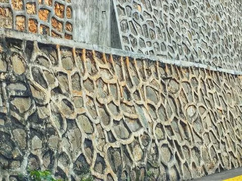 Rough stone wall with irregular circular shapes forming a textured pattern, g Stock Photos