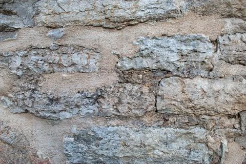 Rough stone wall texture with eroded surface background Stock Photos