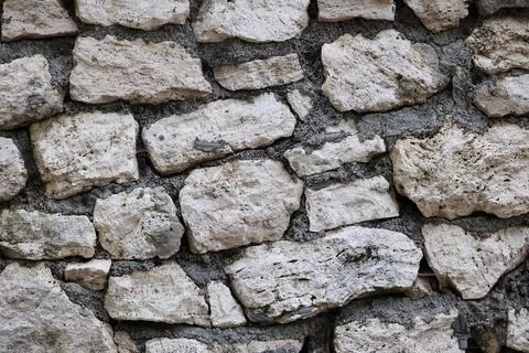 Rough stone wall texture with limestone blocks Stock Photos