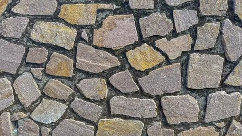 Rough stone wall texture, rich in natural hues and patterns Stock Photos