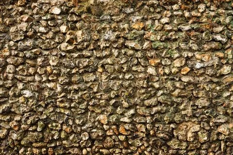 Rough stone wall texture with varied flint rocks and mortar, showing an old.. Stock Photos