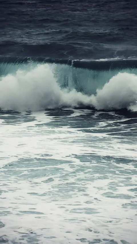 Rough stormy ocean wave crashes into green barrel on dark grey day Stock Footage 315303483