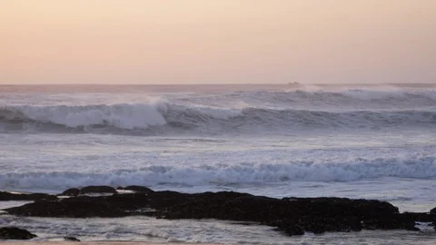 Rough stormy sea with white waves crashing on the rocky beach at dusk Stock Footage 103185451