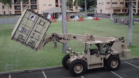 Rough terrain container handler loading cargo truck at US Army barracks 스톡 동영상 83320603
