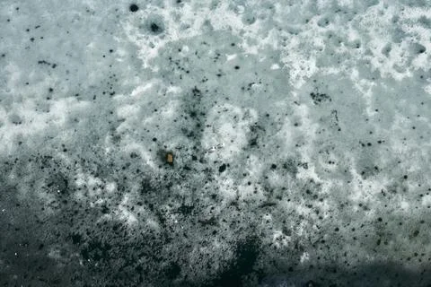 Rough texture of ice and snow with small dark debris and rocks. Abstract na.. Stock Photos