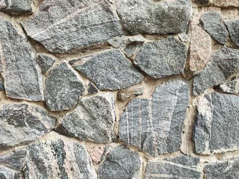 Rough texture old granite stone wall Stock Photos