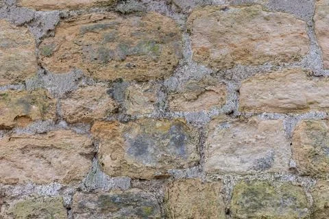 Rough texture of very old weathered stone brick wall with traces of time and  Stock Photos