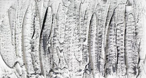 The rough texture of white putty and concrete with black brush stains. Copy Stock Photos