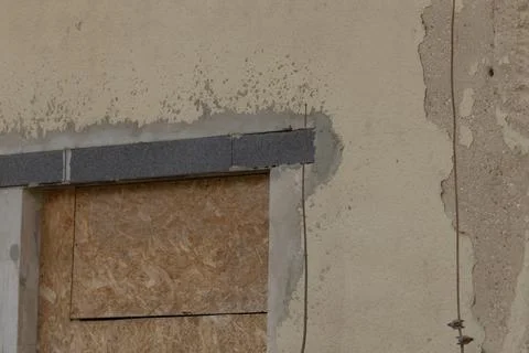 Rough textured boarded window indicating urban renewal or neglect Foto stock