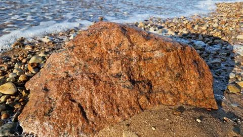 Rough Textured Boulder on Sandy Beach Stock Photos