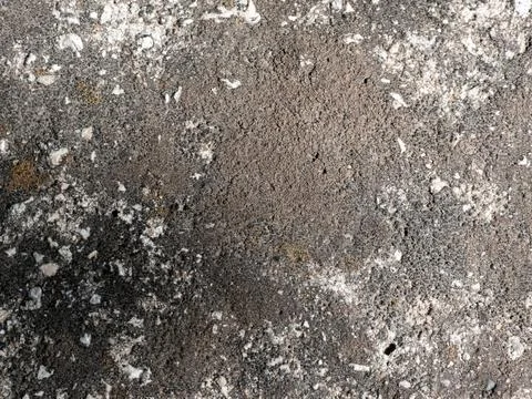 Rough textured concrete surface with cracks and small stones Stock Photos