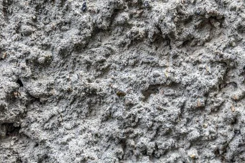 Rough textured concrete surface with embedded aggregate and weathered patches Stock Photos