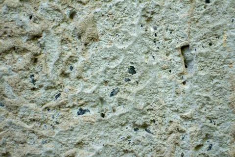 Rough textured light concrete wall background with dark mineral aggregate 库存照片