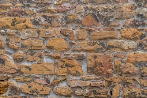 Rough textured stone wall with varied colors and irregular shapes Stock Photos