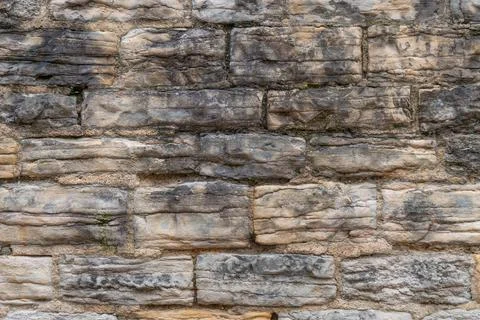 Rough textured stone wall with varied colors and irregular shapes Stock Photos
