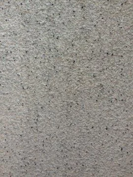 Rough textured wall surface with speckled pattern Stock Photos