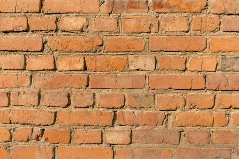 Rough, uneven texture old brick red wall close up. Stock Photos