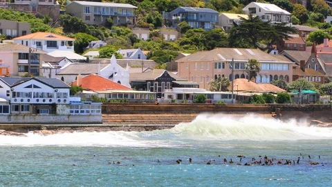 Rough waves crashing on rocks and concrete breakwater wall at Kalk Bay Harbor Stock Footage 119017030