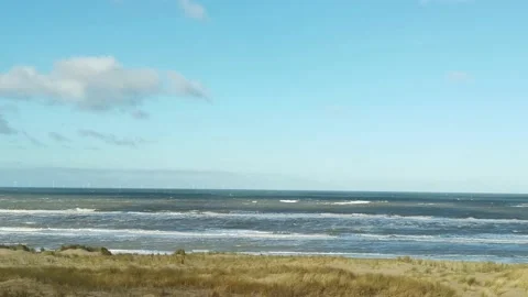 Rough waves of the North sea close to the beach with beach grass in foreground Stock Footage 196857805