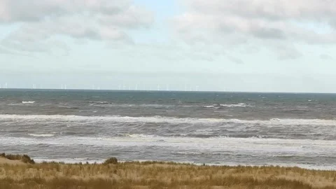 Rough waves of the North sea close to the beach with beach grass in foreground Stock Footage 196874395