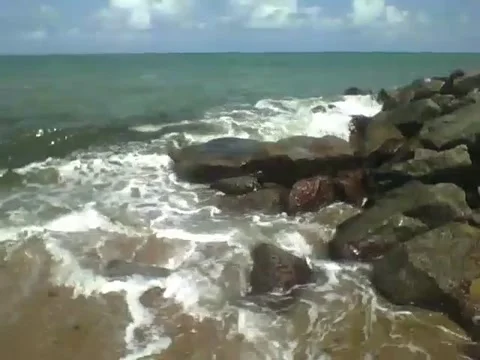 The rough waves of the sea hit the rocks hard on the beach Stock Footage 163684594