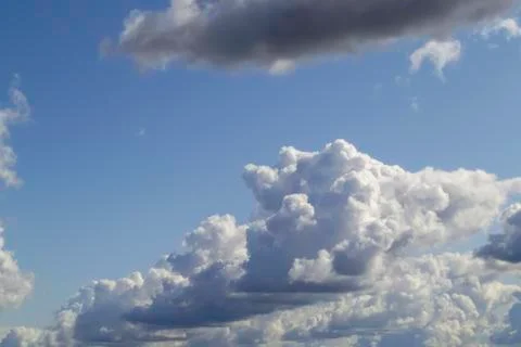 Rough white cumulus clouds on blue sky before rain. Stock Photos