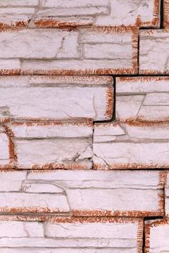 Rough white stone wall surface showing an interlocking block pattern with r.. Stock Photos