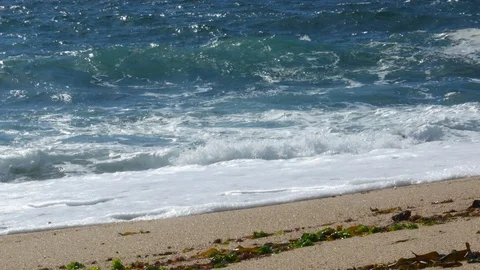 Rough white waves crashing on sandy beach. Slide left. Stock Footage 109260934
