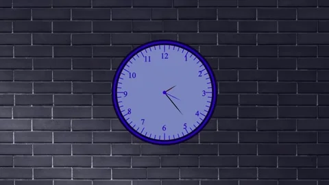 Round analog clock with blue face and hands on a dark gray brick wall time .. Stock Footage 337566968