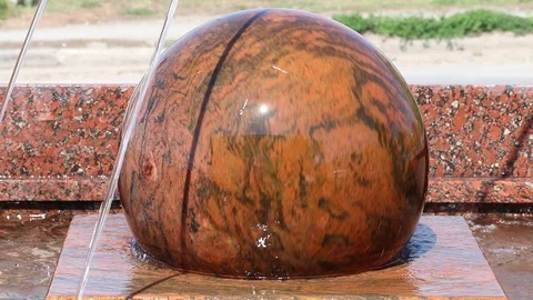 A round ball with a stone rotates on water Stock Footage 129398756