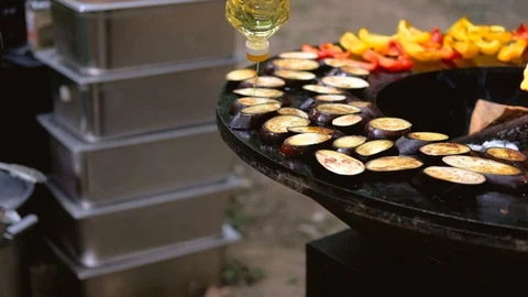 Round barbecue grill with open fire inside. Meals for summer picnic are being Stock Footage 114695039