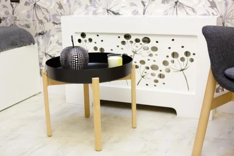Round black bedside table. On the table are candlesticks and a black apple-sh 스톡 사진