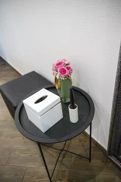 Round black metal table next to it pouf 库存照片
