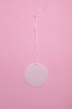 Round blank tag hanging on pink background Stock Photos