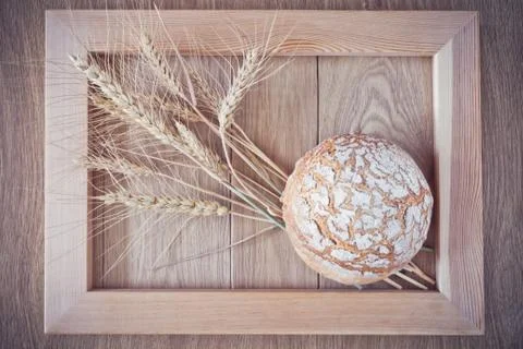 Round bread and spikelets Stock Photos
