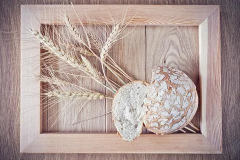 Round bread and spikelets Stock Photos