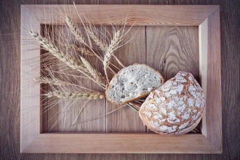 Round bread and spikelets Stock Photos