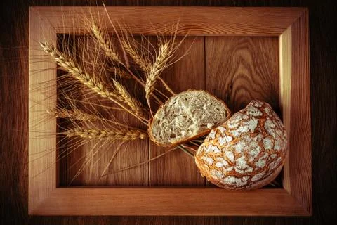 Round bread and spikelets Stock Photos