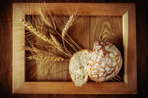 Round bread and spikelets Stock Photos