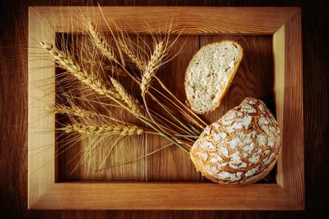 Round bread and spikelets Stock Photos
